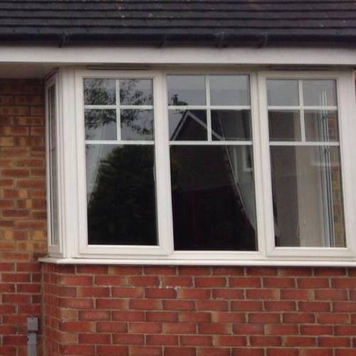 A bay window on the front of a brick house